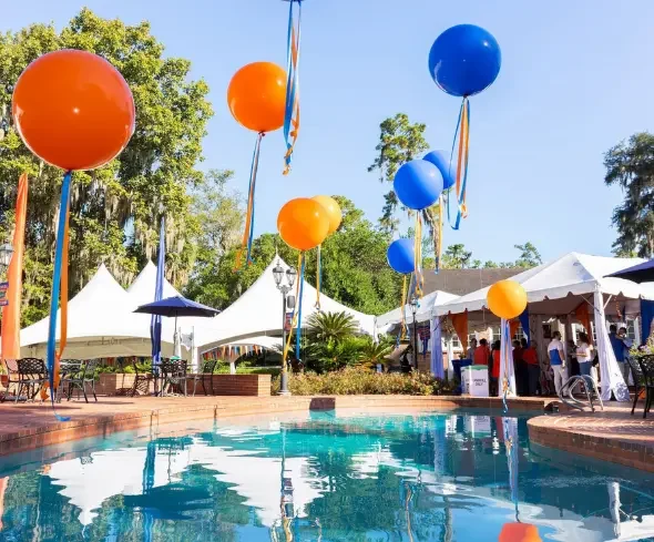 University house pool with orange and blue balloon decorations